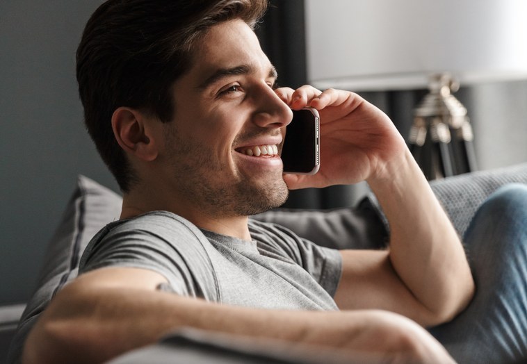 Un uomo sul divano risponde al telefono