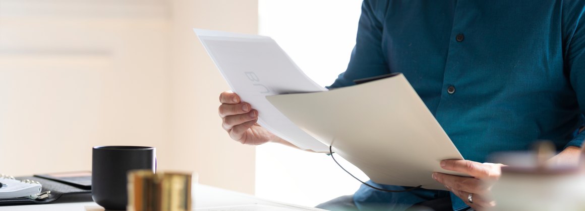 Una persona sfoglia dei documenti in ufficio