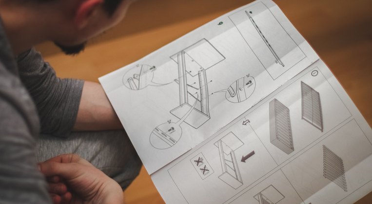 Un foglio di istruzioni di montaggio letto al tavolo